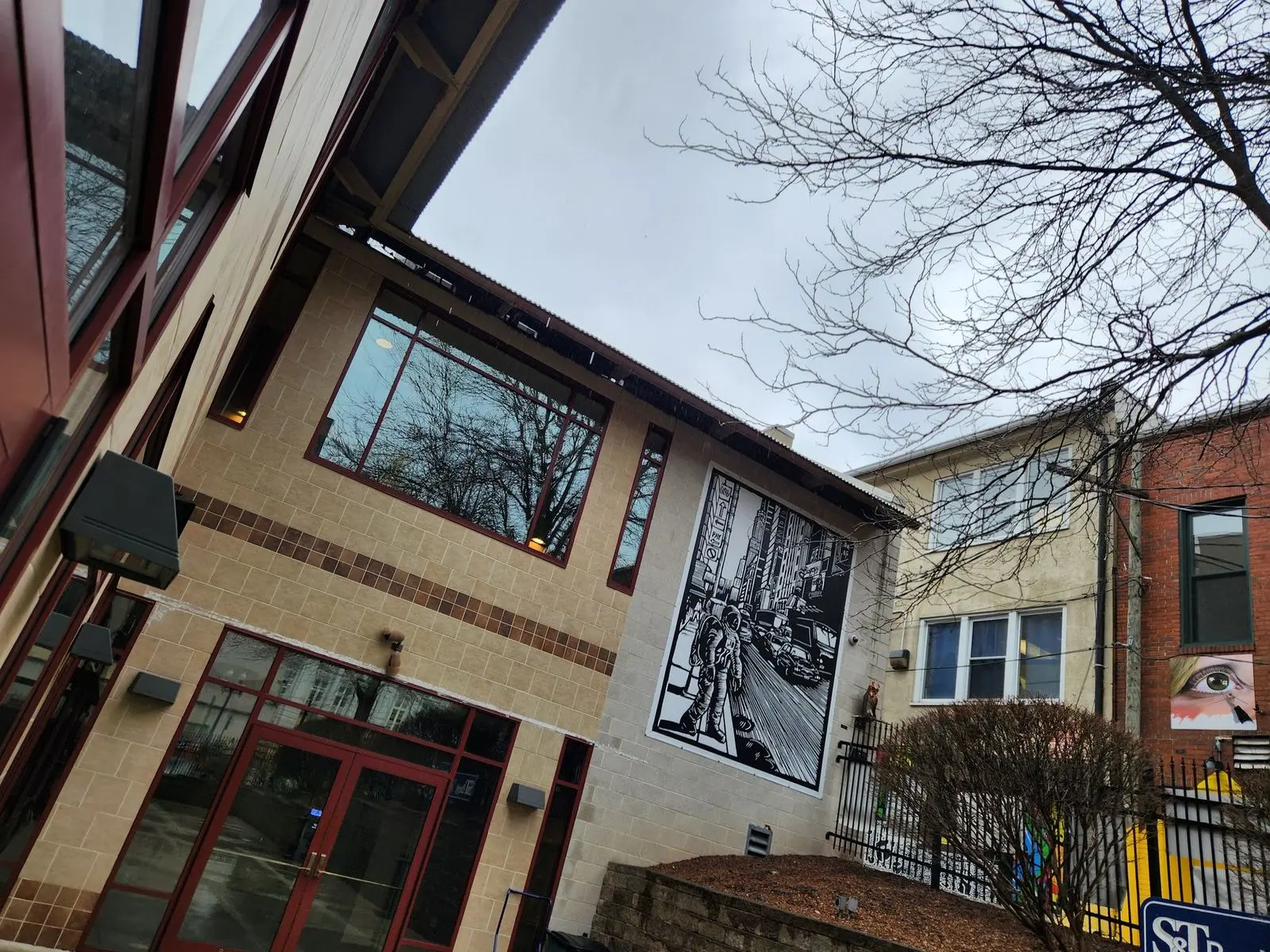 Three colleagues discuss an architectural project using a laptop and tablet.