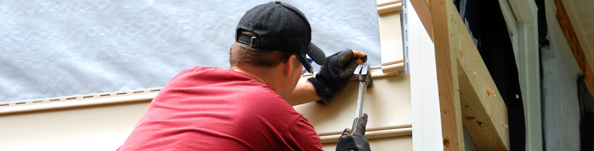 Man nailing siding to house